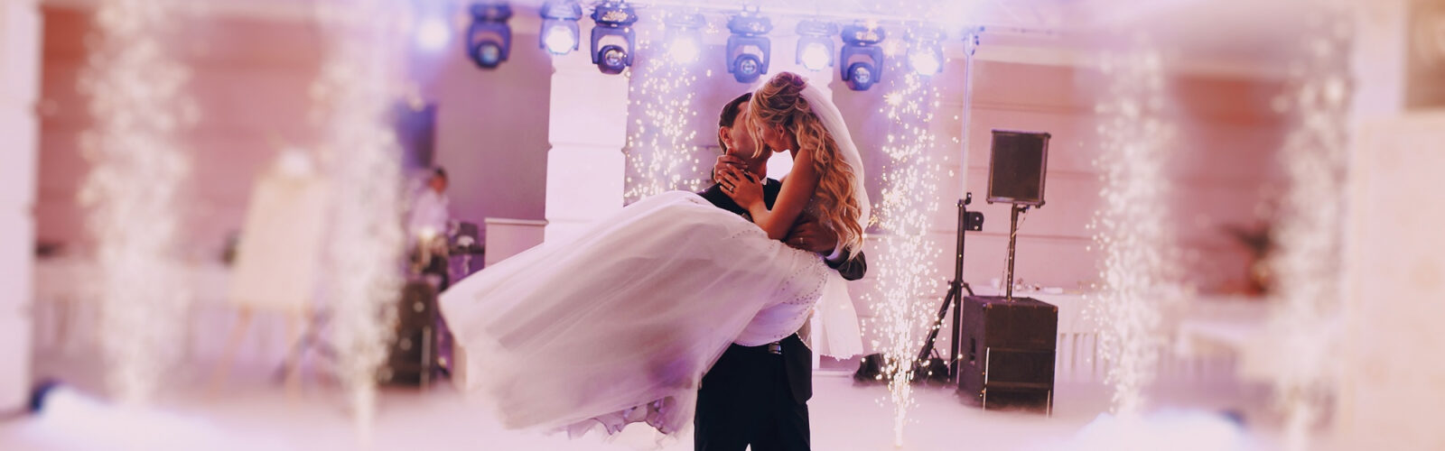 Junges glückliches Brautpaar beim Hochzeitstanz mit Konfetti und Lichteffekten
